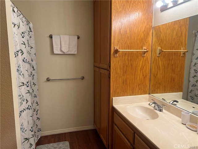 full bathroom featuring curtained shower, baseboards, wood finished floors, and vanity