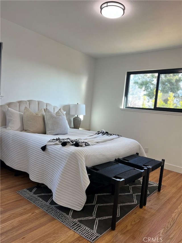 bedroom featuring light wood-type flooring and baseboards