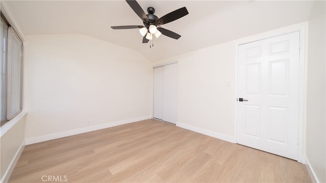 unfurnished room featuring a ceiling fan, vaulted ceiling, light wood-style floors, and baseboards