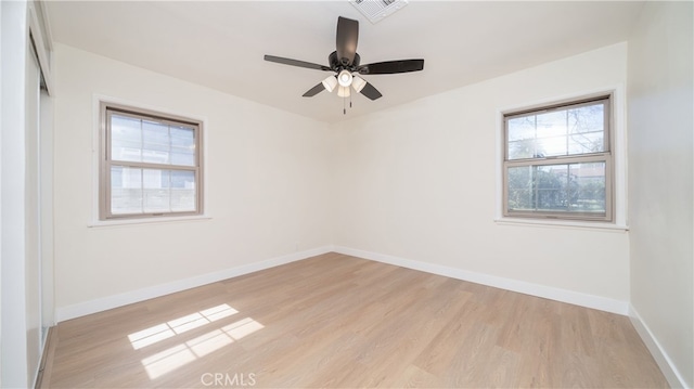 spare room with baseboards, visible vents, light wood finished floors, and ceiling fan