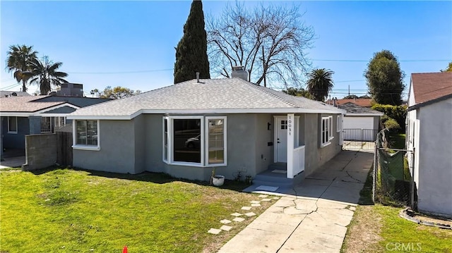 view of front of home with stucco siding, fence, a front lawn, and a shingled roof