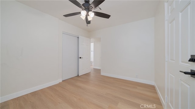 empty room featuring light wood-style flooring, baseboards, and ceiling fan