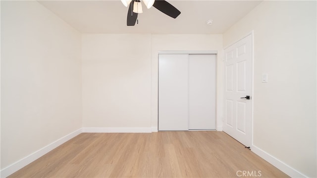 unfurnished bedroom featuring light wood finished floors, ceiling fan, a closet, and baseboards