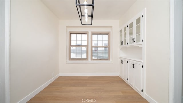 interior space featuring light wood-type flooring and baseboards