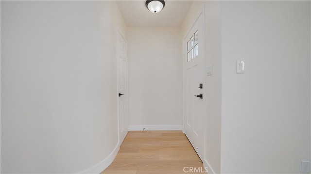 doorway to outside with baseboards and light wood-style floors