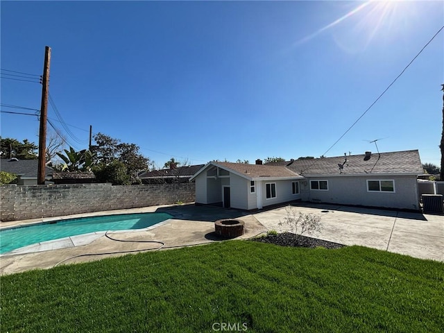 view of swimming pool with a patio, a fenced in pool, a fenced backyard, a fire pit, and a lawn