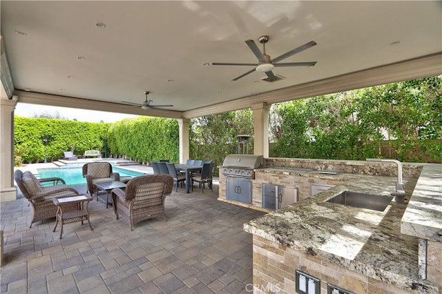 68340 Verano Rd, Cathedral City, CA 92234 - view of patio / terrace with area for grilling, a ceiling fan, a sink, a fenced in pool, and an outdoor kitchen