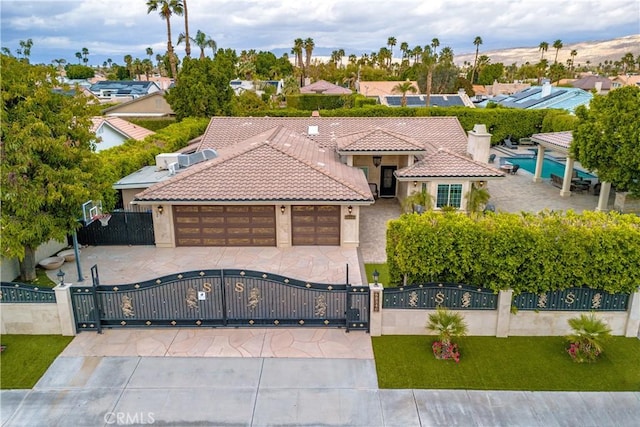 68340 Verano Rd, Cathedral City, CA 92234 - mediterranean / spanish-style house featuring a gate, stucco siding, a garage, a fenced front yard, and a tile roof