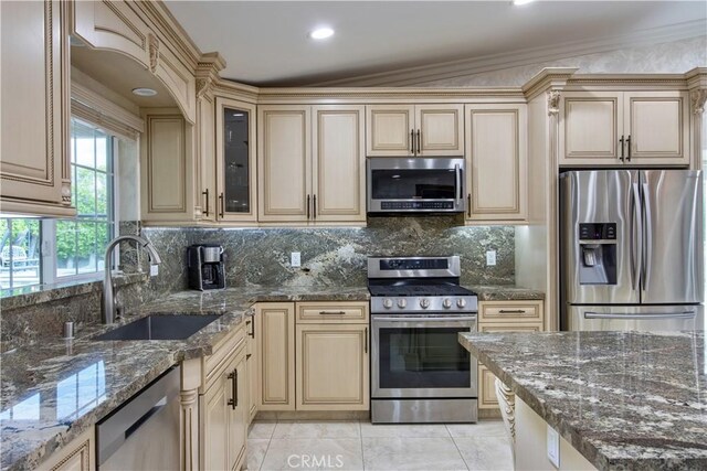 68340 Verano Rd, Cathedral City, CA 92234 - kitchen featuring ornamental molding, a sink, appliances with stainless steel finishes, cream cabinets, and tasteful backsplash