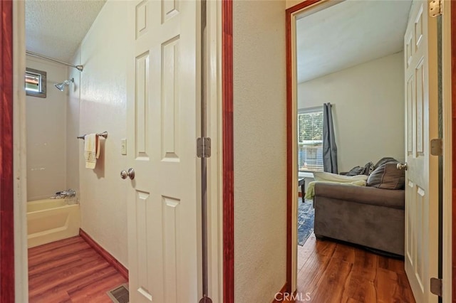 22292 N Tuolumne Rd, Twain Harte, CA 95383 - hallway with visible vents, a textured ceiling, and wood finished floors