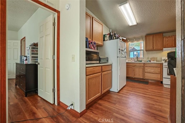 22292 N Tuolumne Rd, Twain Harte, CA 95383 - kitchen with white appliances, dark wood-style floors, under cabinet range hood, and a sink