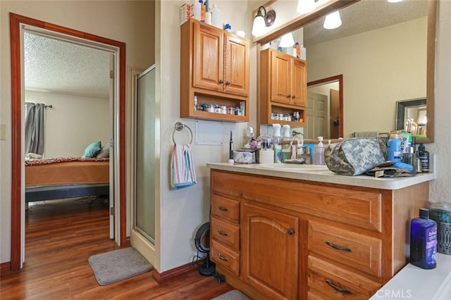 22292 N Tuolumne Rd, Twain Harte, CA 95383 - ensuite bathroom featuring connected bathroom, a shower stall, wood finished floors, a textured ceiling, and vanity