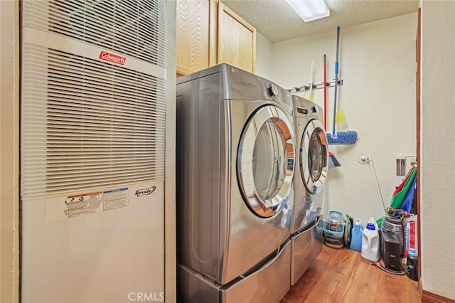 22292 N Tuolumne Rd, Twain Harte, CA 95383 - clothes washing area with independent washer and dryer, a textured ceiling, wood finished floors, cabinet space, and a heating unit