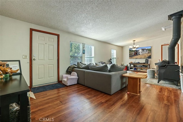 22292 N Tuolumne Rd, Twain Harte, CA 95383 - living room featuring a wood stove, a notable chandelier, wood finished floors, and a textured ceiling
