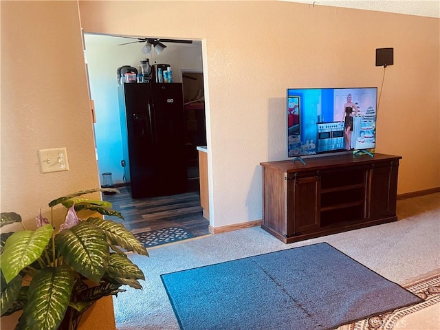 interior space featuring carpet, baseboards, and ceiling fan