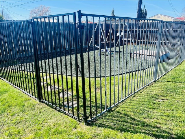 view of gate with a yard and fence