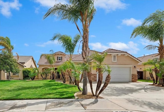 mediterranean / spanish-style home with concrete driveway, a tiled roof, stucco siding, a front lawn, and a garage