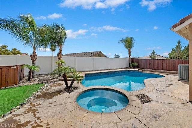 view of swimming pool featuring a pool with connected hot tub, a patio, a fenced backyard, and central AC unit