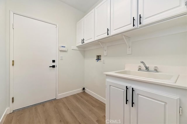 laundry area with a sink, light wood-style floors, baseboards, hookup for a washing machine, and cabinet space