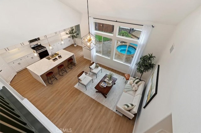 living room with lofted ceiling, wood finished floors, and visible vents