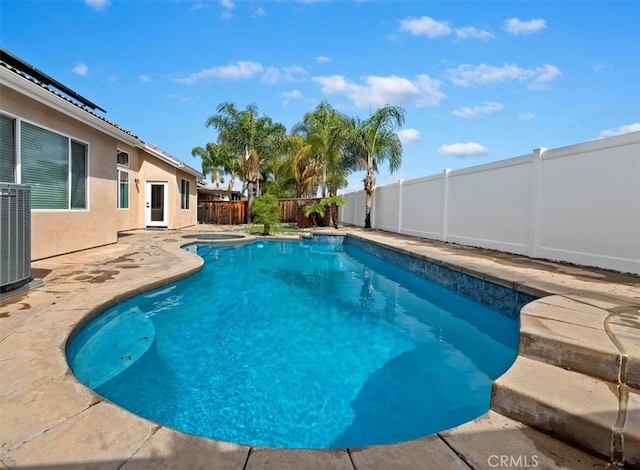 view of swimming pool with a patio, a fenced backyard, central AC unit, and a fenced in pool