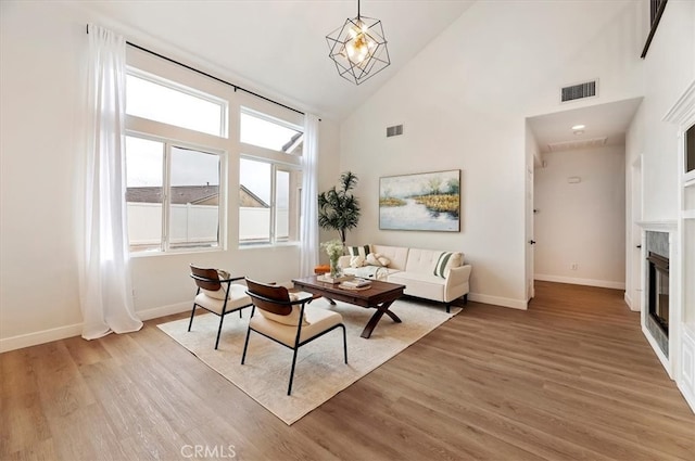 living area with visible vents, high vaulted ceiling, and baseboards