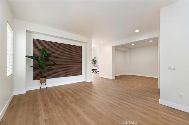 empty room with baseboards, recessed lighting, and light wood-style floors