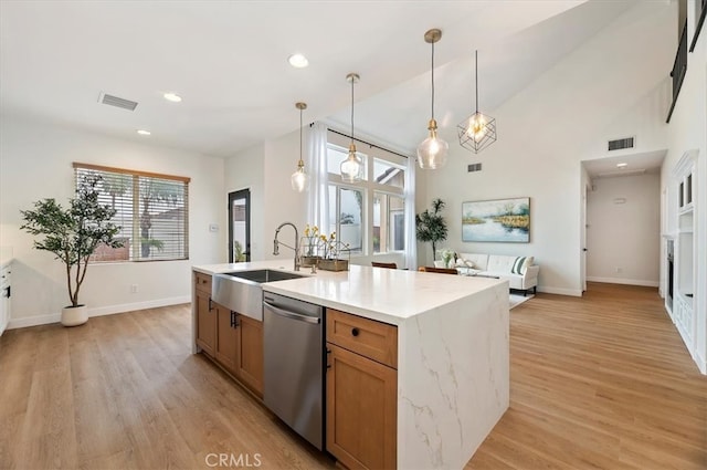 kitchen with stainless steel dishwasher, light wood-style flooring, visible vents, and a sink