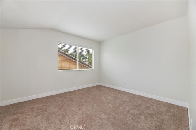 unfurnished room with vaulted ceiling, baseboards, and carpet floors