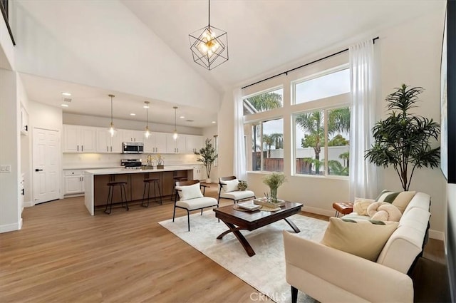 living room with recessed lighting, light wood-type flooring, baseboards, and high vaulted ceiling