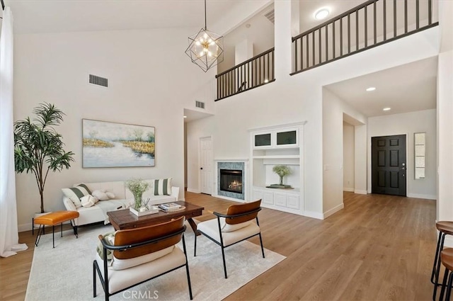 living room with baseboards, visible vents, wood finished floors, and built in features