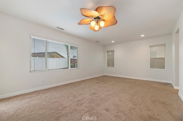 empty room with light colored carpet, visible vents, baseboards, recessed lighting, and a ceiling fan