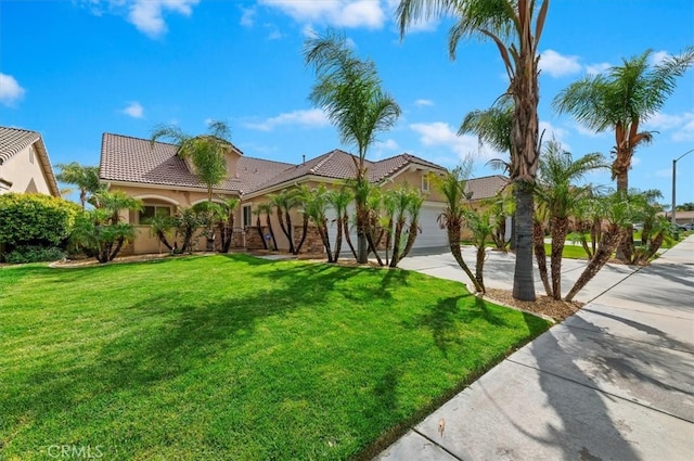 mediterranean / spanish-style home featuring a front lawn, driveway, a garage, and stucco siding