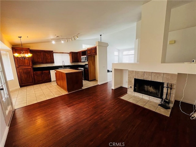 kitchen featuring a sink, stainless steel appliances, lofted ceiling, and a kitchen island