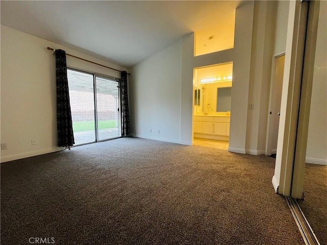 interior space with access to exterior, baseboards, vaulted ceiling, carpet floors, and ensuite bath