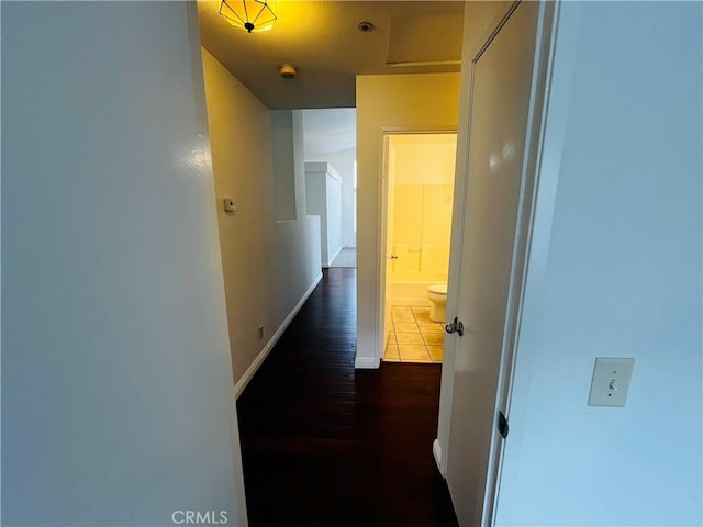 hall with dark wood-type flooring and baseboards