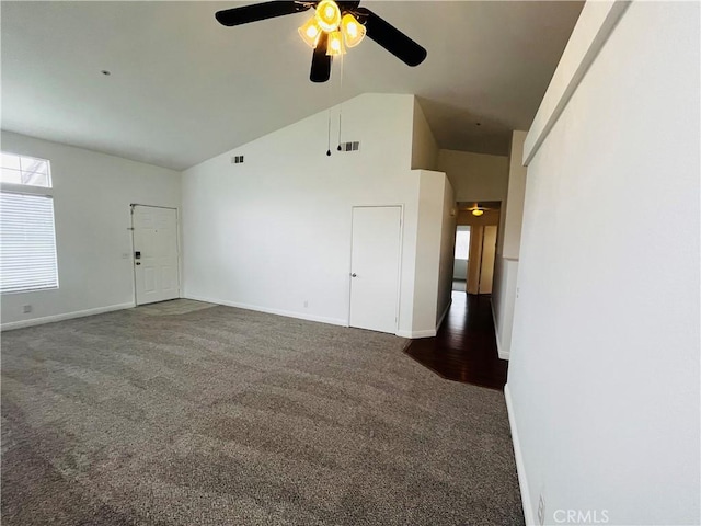 carpeted spare room with vaulted ceiling, visible vents, baseboards, and ceiling fan