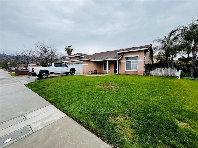 ranch-style house featuring stucco siding, driveway, fence, a front yard, and a garage