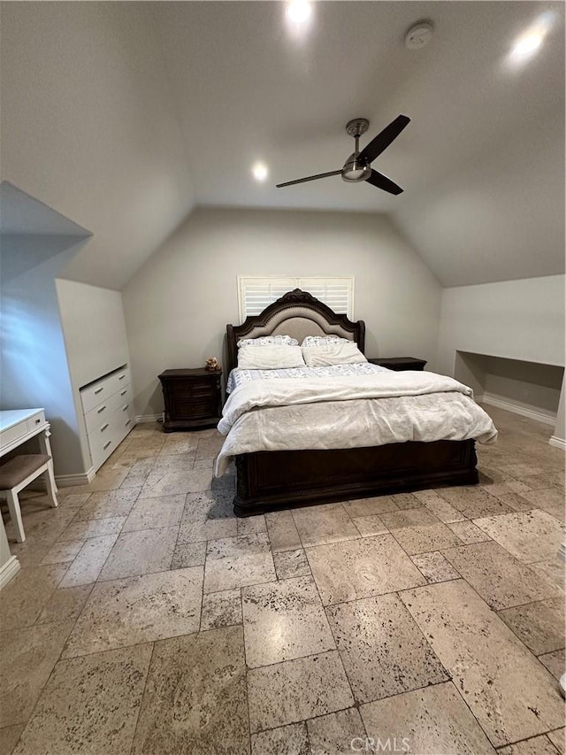 bedroom with baseboards, lofted ceiling, and stone tile floors