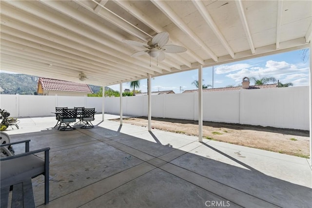 view of patio featuring a fenced backyard, a ceiling fan, and outdoor dining area