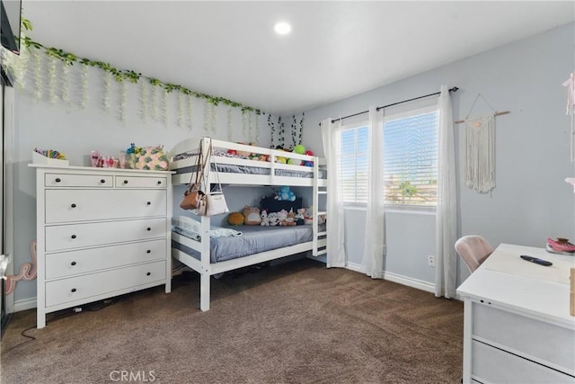 bedroom featuring baseboards and dark carpet