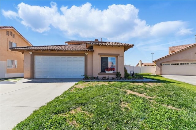 mediterranean / spanish house with a tile roof, concrete driveway, stucco siding, and a front lawn