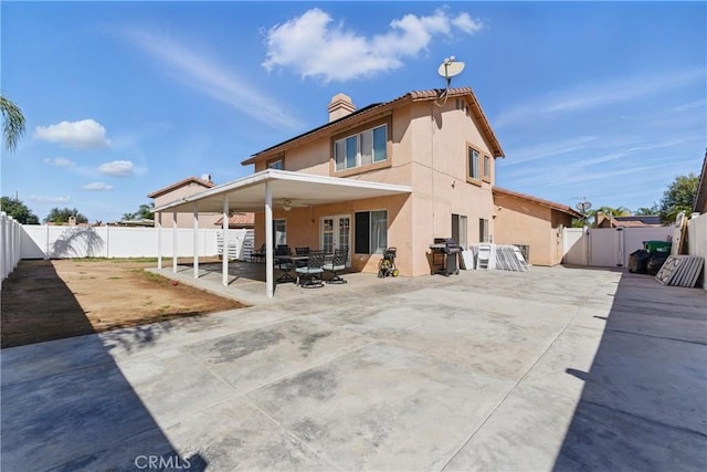 rear view of property with a gate, a patio, a fenced backyard, stucco siding, and french doors