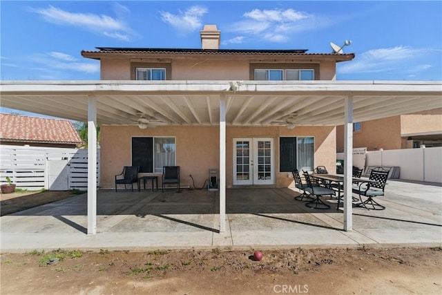 back of property featuring fence, stucco siding, a patio, and french doors