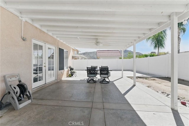 view of patio with outdoor dining area, a fenced backyard, french doors, and ceiling fan