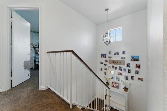 stairway featuring a notable chandelier and carpet floors