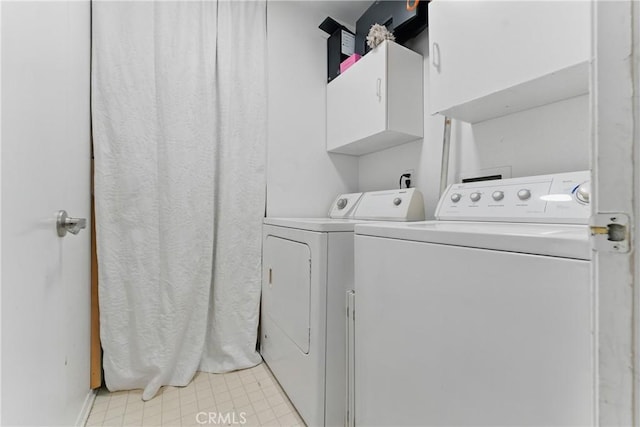 laundry area with washing machine and clothes dryer and cabinet space