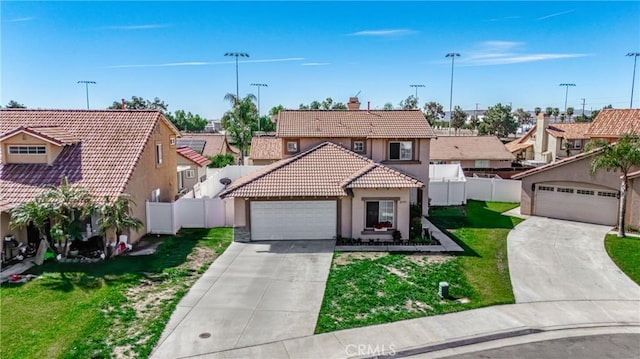 view of front of property with a front yard, concrete driveway, a chimney, stucco siding, and a tiled roof