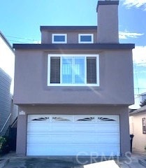 view of front facade with concrete driveway, a garage, and stucco siding