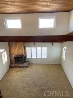 unfurnished living room with wooden ceiling, a high ceiling, and plenty of natural light